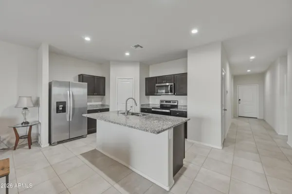 a kitchen with stainless steel appliances granite countertop a refrigerator and a stove top oven
