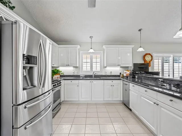 a kitchen with granite countertop cabinets and steel stainless steel appliances