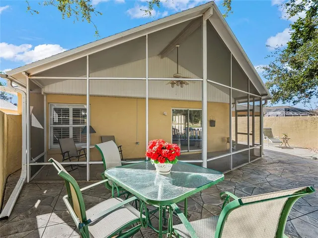 a patio with table and chairs and potted plants