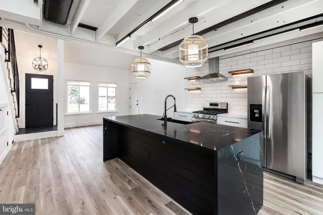 a kitchen with stainless steel appliances granite countertop a sink refrigerator and cabinets