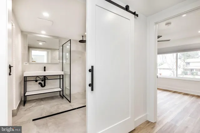 a large white kitchen with white cabinets and wooden floor