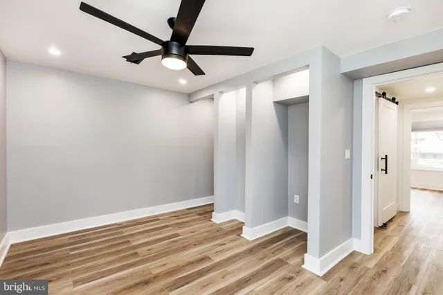 a view of room with wooden floor and ceiling fan