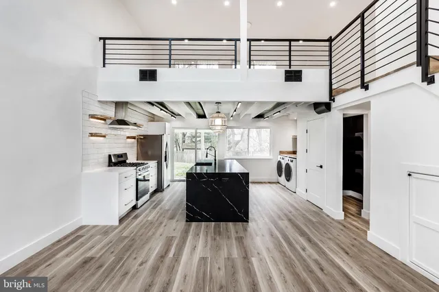 a kitchen with stainless steel appliances granite countertop a refrigerator and a stove