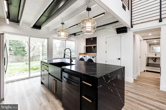a kitchen with stainless steel appliances granite countertop a sink a stove and a wooden floors