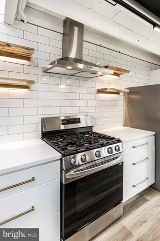 a stove top oven sitting inside of a kitchen