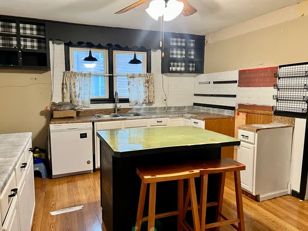 a kitchen with a sink a stove and chairs