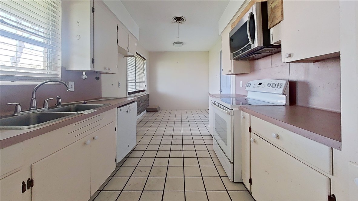 4245 Dody Street Corpus Christi, TX 78411 - Photo 12 of 15 a kitchen with stainless steel appliances a sink stove top oven and cabinets
