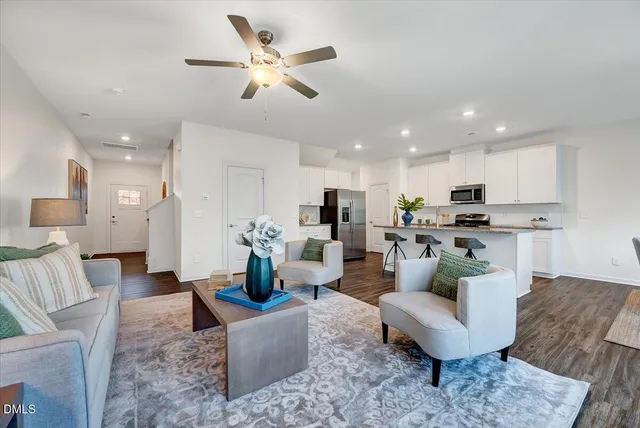 a living room with furniture kitchen view and a chandelier