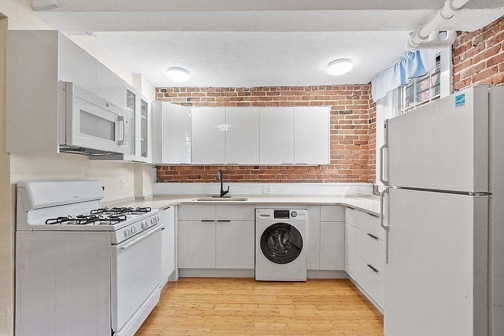 6 Radcliffe Road, Unit B Boston, MA 02134 - Photo 8 of 25 a kitchen with a stove and a refrigerator
