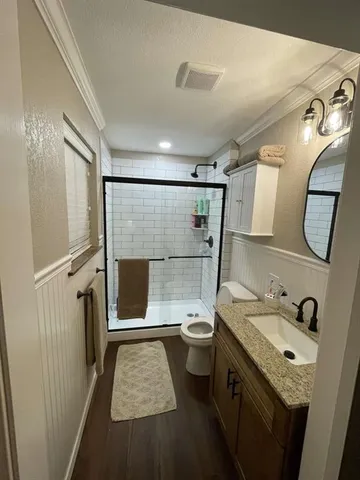 a bathroom with a granite countertop sink toilet and shower