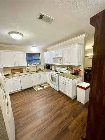 a kitchen with a white cabinets and white appliances