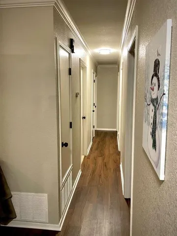 a view of a hallway with wooden floor