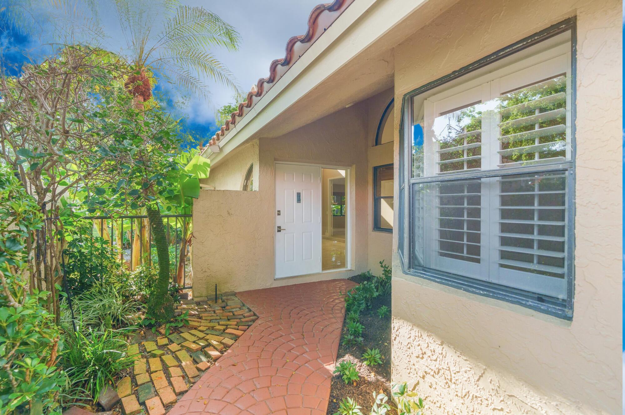 22545 Meridiana Drive Boca Raton, FL 33433 - Photo 4 of 63 a front view of a house with a yard