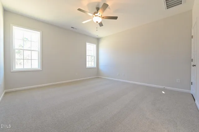 an empty room with a ceiling fan and a window
