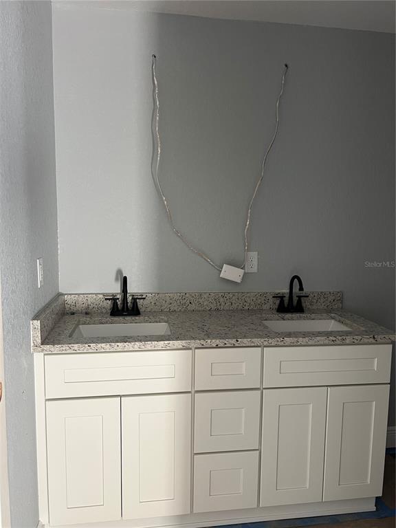 20050 Southwest 80th Pl Road Dunnellon, FL 34431 - Photo 7 of 10 a bathroom with a granite countertop sink and white cabinets