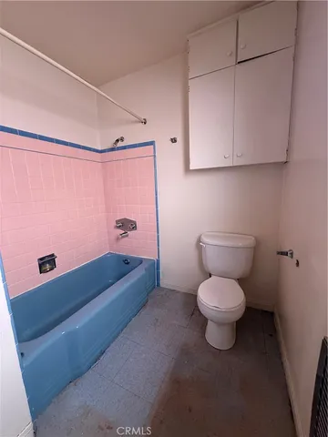 a bathroom with a granite countertop toilet and a sink
