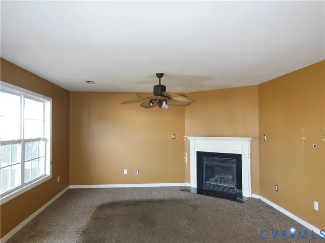 an empty room with a fireplace and windows