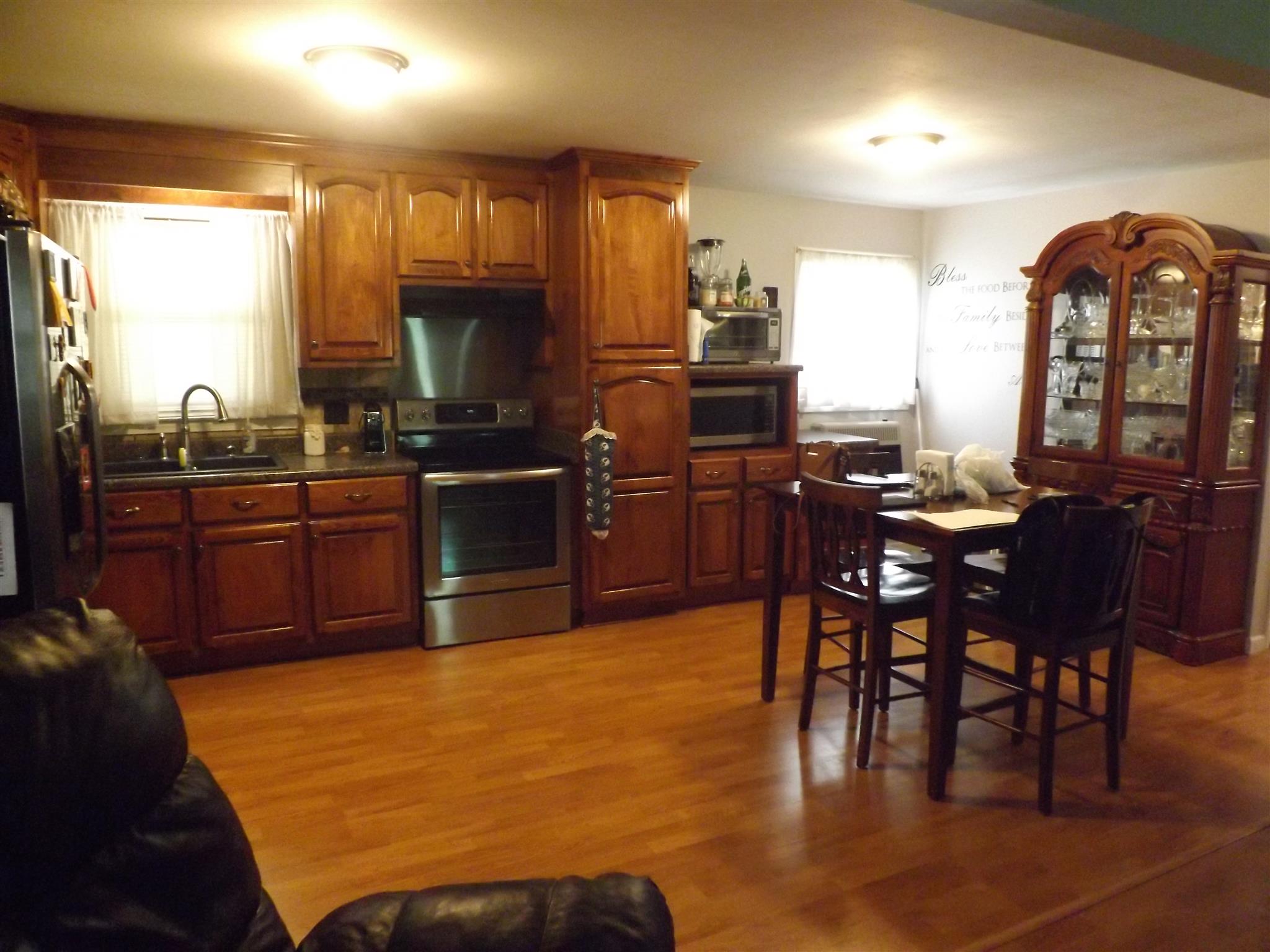 1397 Oak Grove Road Goodspring, TN 38460 - Photo 9 of 25 a kitchen with stainless steel appliances granite countertop a stove top oven a sink a dining table and chairs with wooden floor