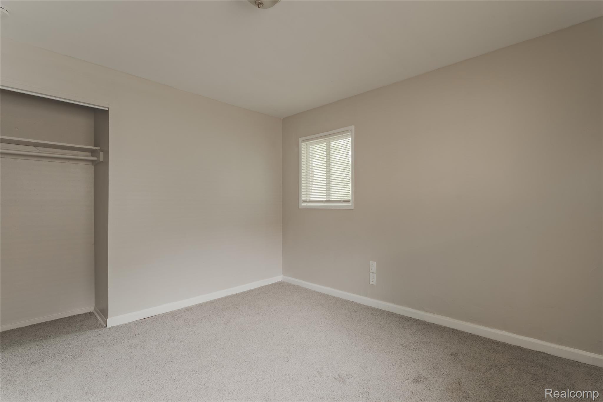 93 West Princeton Avenue Pontiac, MI 48340 - Photo 18 of 31 Neutral-toned wall finishes, light-colored carpeting, white trim, and a window providing natural illumination