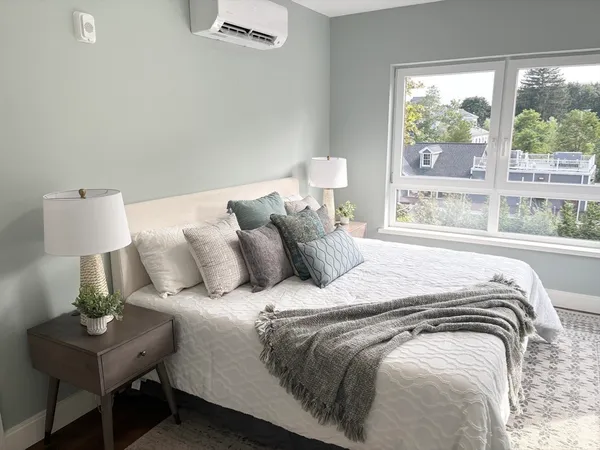 a large bed sitting in a bedroom next to a window