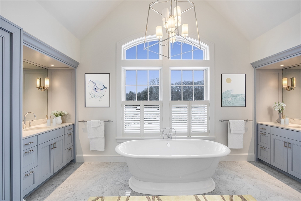 30 Field Road Sudbury, MA 01776 - Photo 19 of 38 a spacious bathroom with a double vanity sink a mirror a bathtub and next to a window