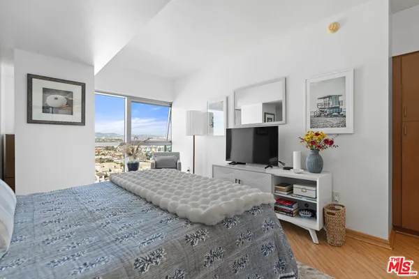 a bedroom with a bed and a flat screen tv