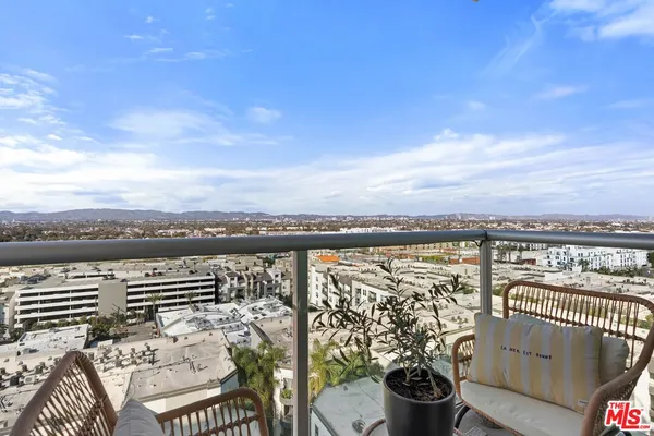 a view of a balcony with chairs and table