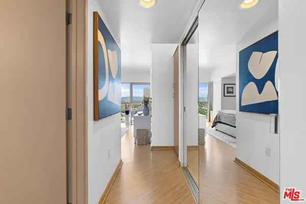 a view of a hallway with wooden floor and a living room