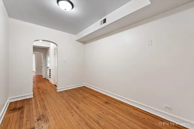 a view of a room with wooden floor and a ceiling fan