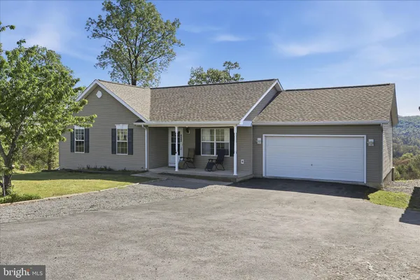a front view of a house with a garden and yard