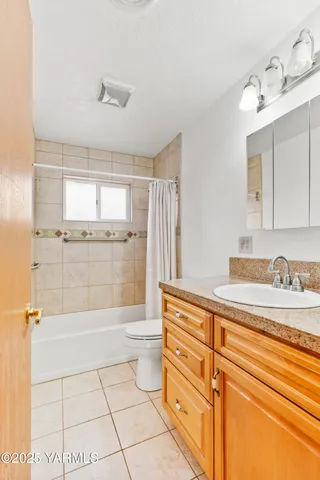 a bathroom with a granite countertop sink a toilet and shower