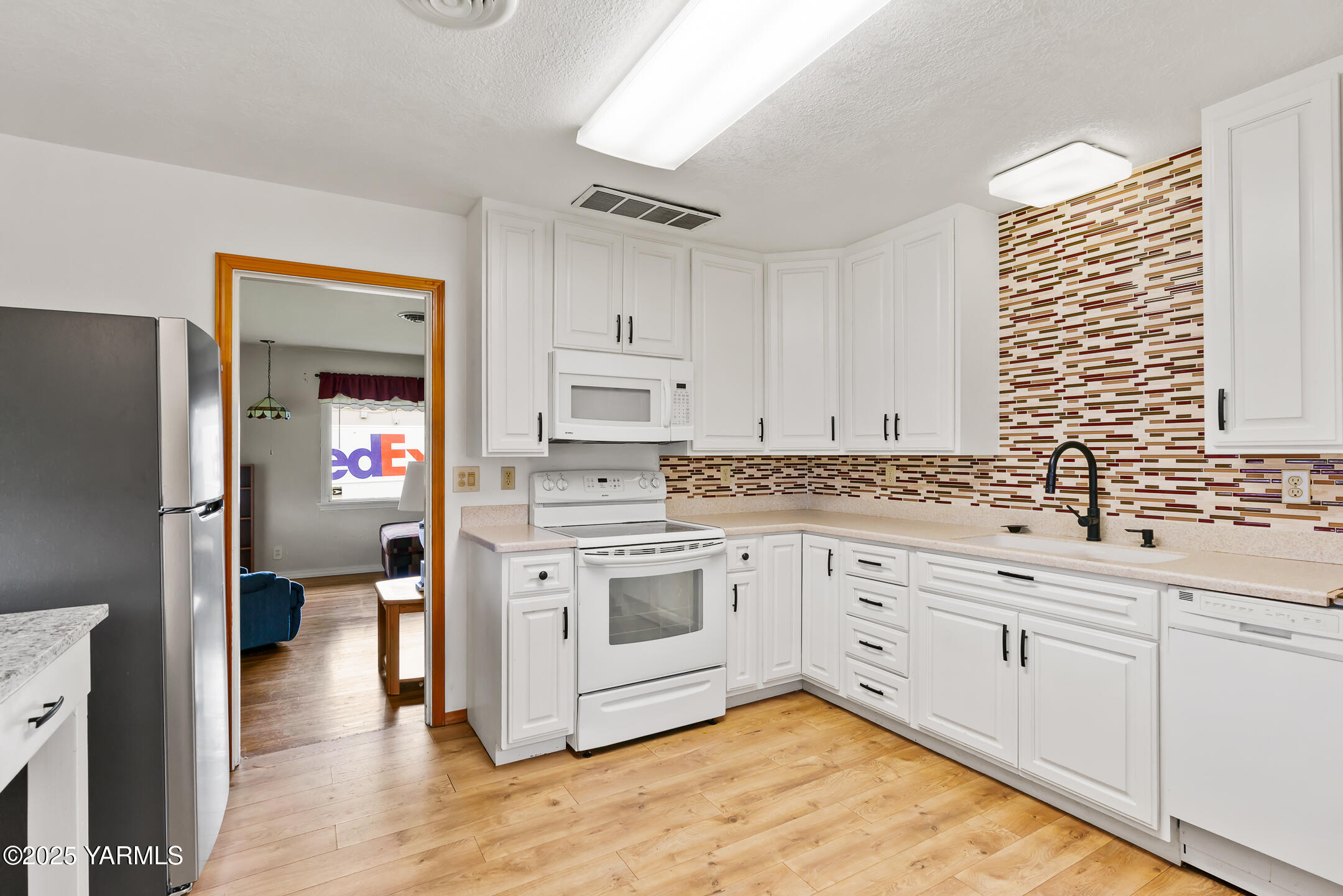 4101 Snowmountain Road Yakima, WA 98908 - Photo 7 of 15 a kitchen with granite countertop white cabinets and white appliances