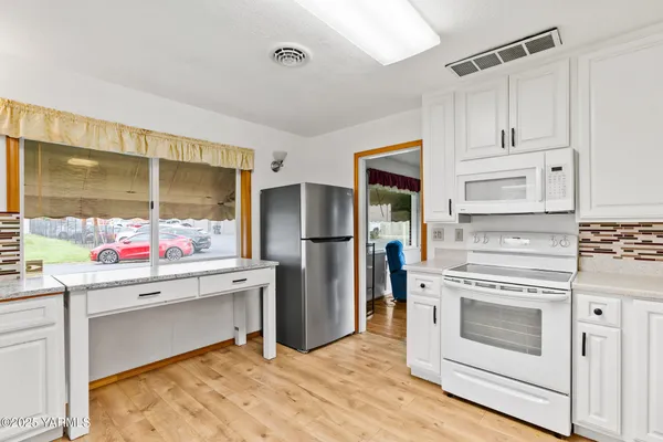 a kitchen with a stove and white cabinets