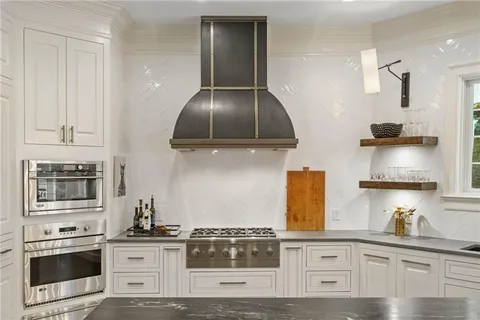 a kitchen with stainless steel appliances granite countertop wooden floors and stove