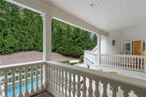 a bedroom with a bed a table and large windows