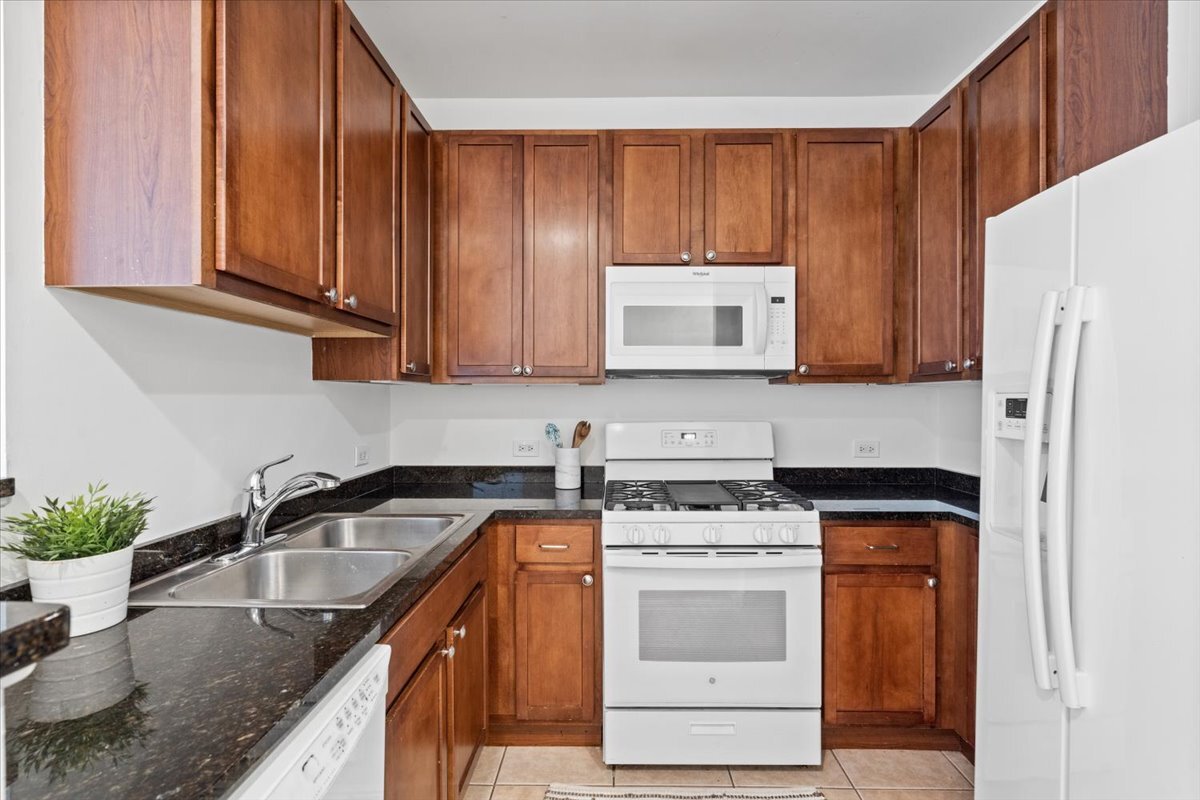 3021 West Armitage Avenue, Unit 208 Chicago, IL 60647 - Photo 8 of 18 a kitchen with stainless steel appliances granite countertop a sink stove and refrigerator