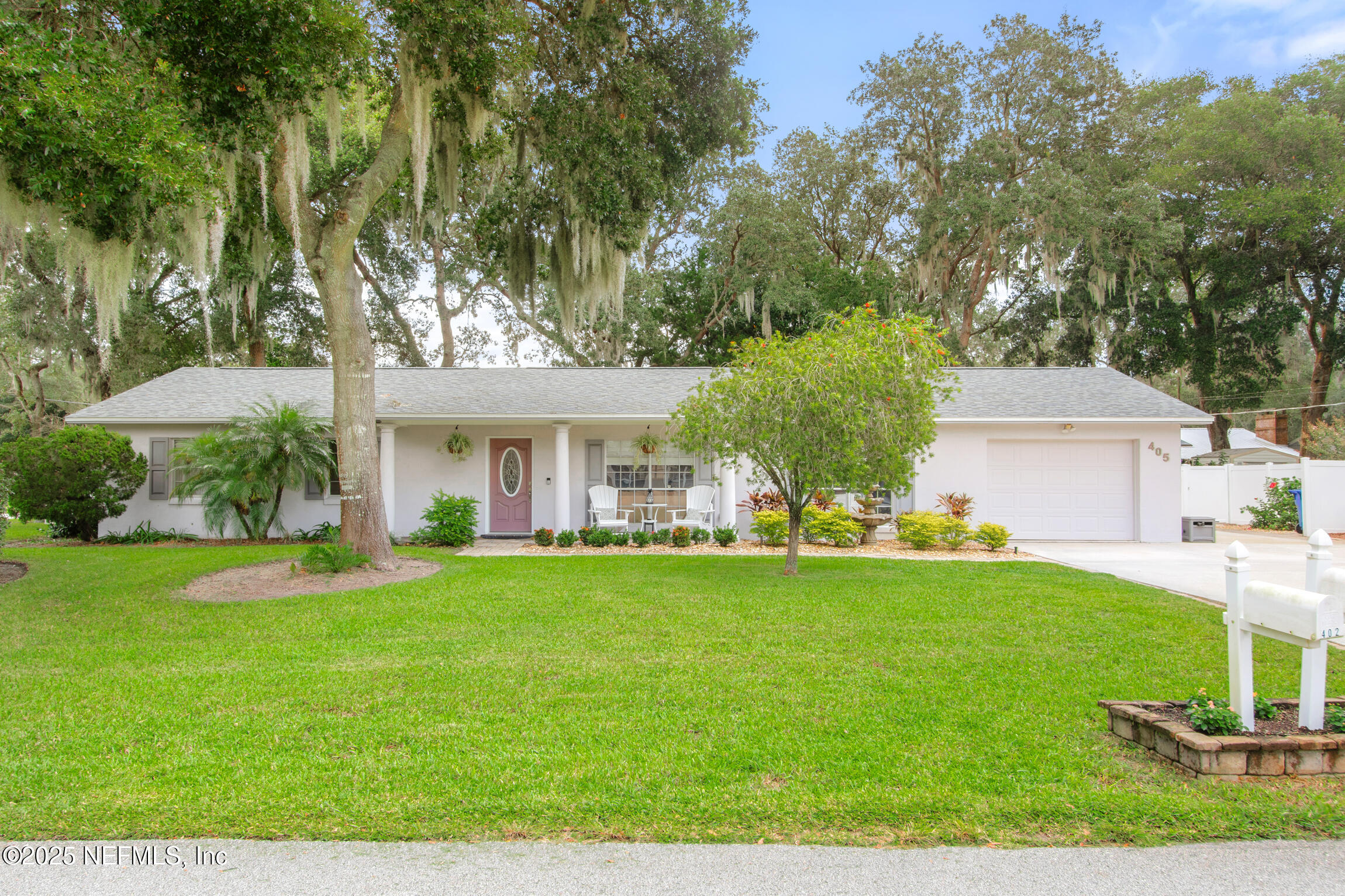 405 Lobelia Road St. Augustine, FL 32086 - Photo 1 of 40 a front view of a house with a garden and trees