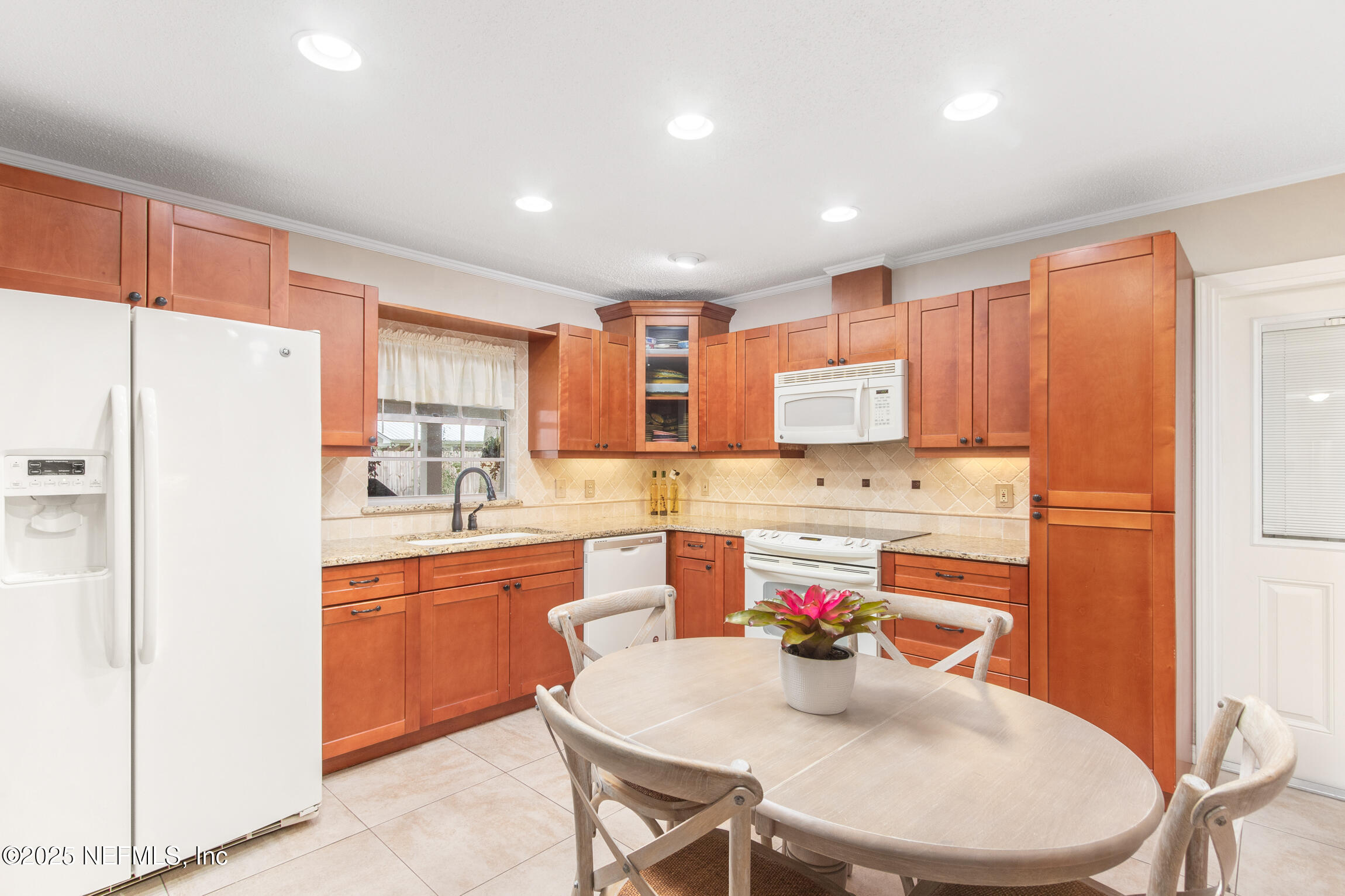 405 Lobelia Road St. Augustine, FL 32086 - Photo 12 of 40 a kitchen with stainless steel appliances a dining table chairs refrigerator sink and cabinets