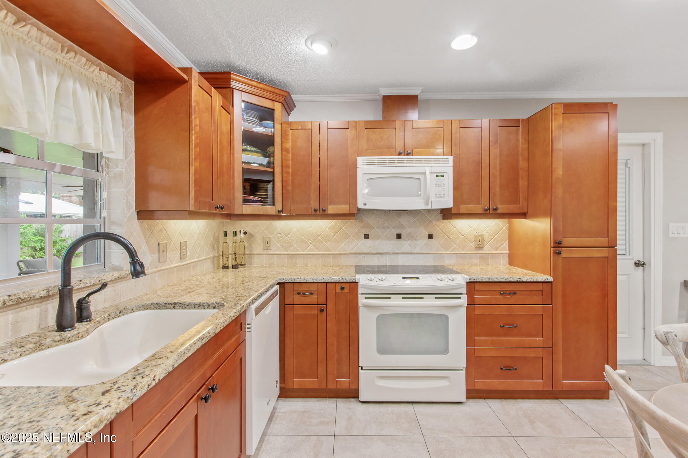 405 Lobelia Road St. Augustine, FL 32086 - Photo 10 of 40 a kitchen with stainless steel appliances granite countertop a sink and cabinets