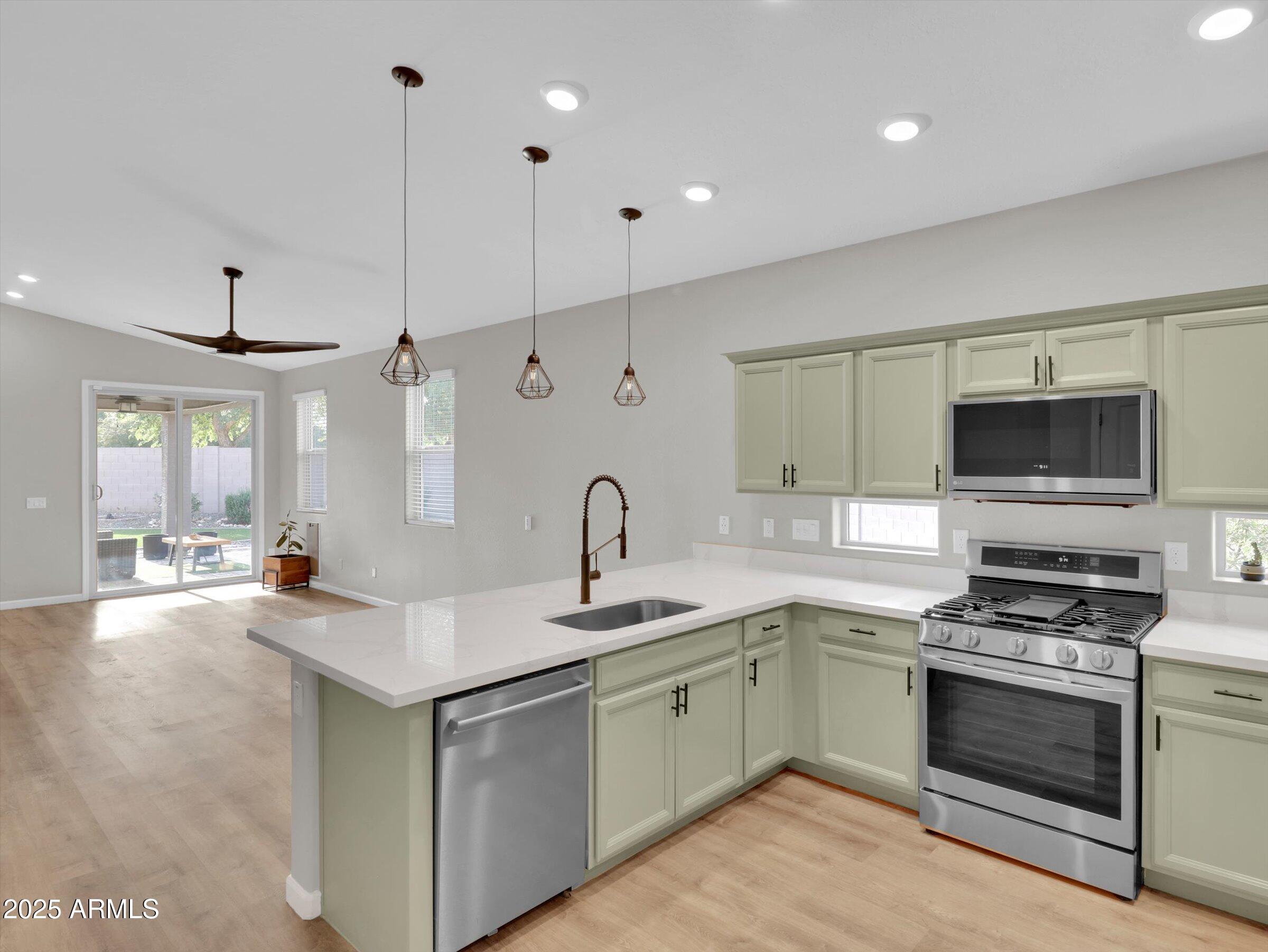 3405 West Alta Vista Road Phoenix, AZ 85041 - Photo 12 of 40 a kitchen with stainless steel appliances a stove sink and microwave