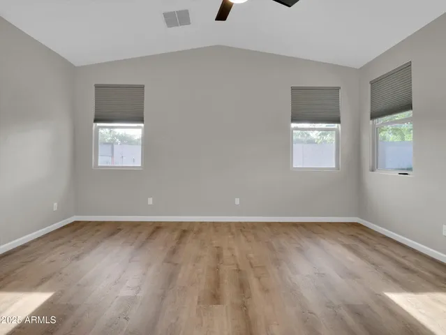 a view of empty room with wooden floor