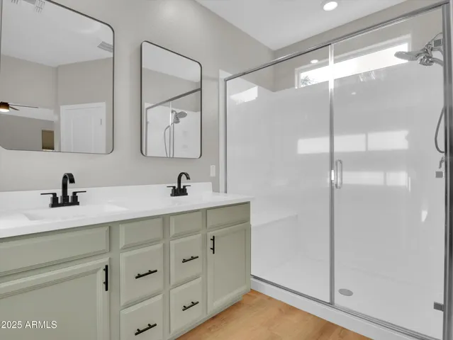 a bathroom with a double vanity sink mirror and shower