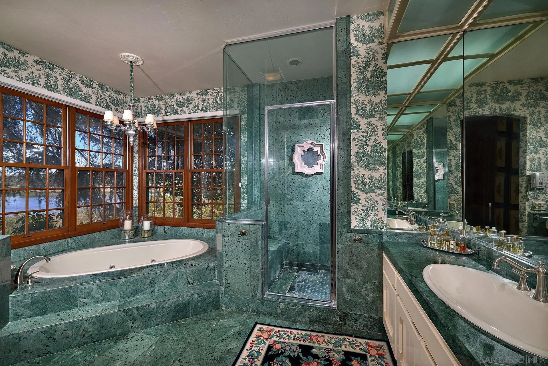 6525 Lago Lindo Rancho Santa Fe, CA 92067 - Photo 22 of 47 Ensuite are his and hers bathrooms and dressing rooms. The lady’s bath has an oversized walk-in closet, a sumptuous bathroom and dressing area that features emerald green marble tiling, matching green pastoral toile wall coverings, and a free-standing tub