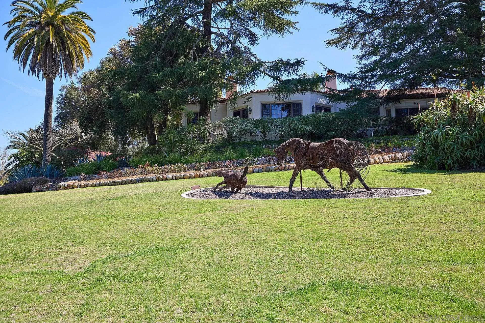 6525 Lago Lindo Rancho Santa Fe, CA 92067 - Photo 33 of 47 On the front lawn a barbed wire sculpture, titled “Mare and Foal”, by P. J. Mene with a view back to the Hahncienda and the Primary Bedroom Retreat.