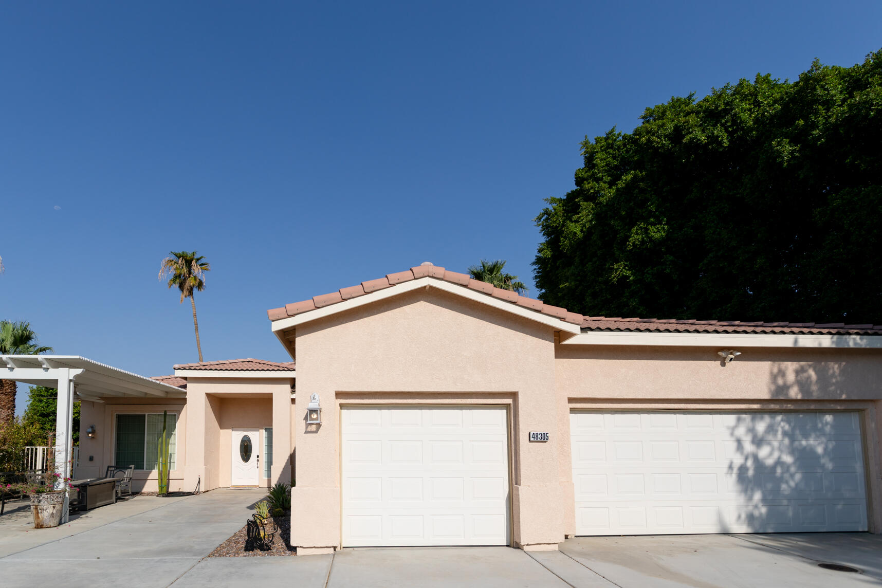 48305 Pic Way Indio, CA 92201 - Photo 76 of 80 a view of a white house with a large window and potted plants