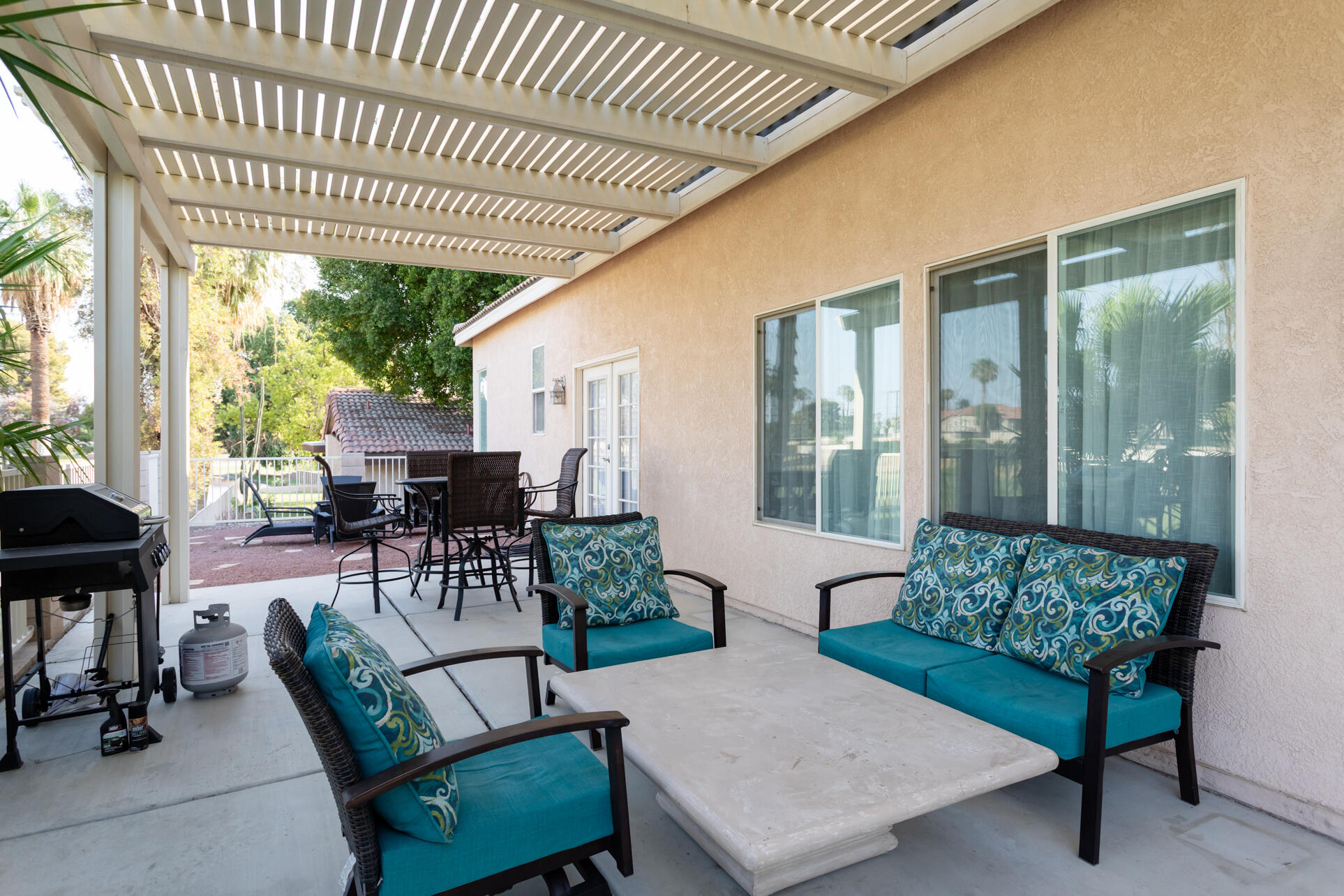 48305 Pic Way Indio, CA 92201 - Photo 77 of 80 a view of a patio with couches table and chairs and potted plants