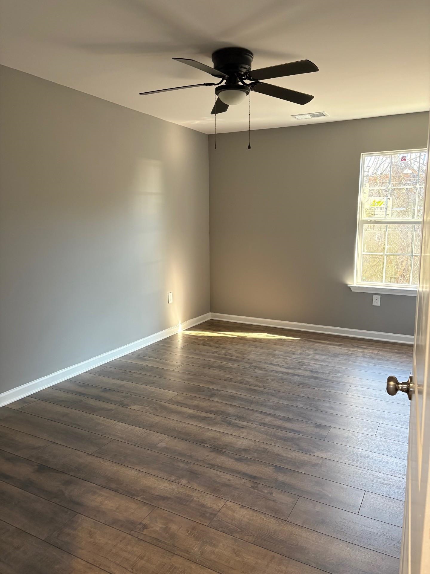3723 Whittier Road Memphis, TN 38108 - Photo 7 of 11 a view of an empty room with wooden floor and a window