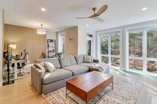 a living room with furniture a large window and a rug