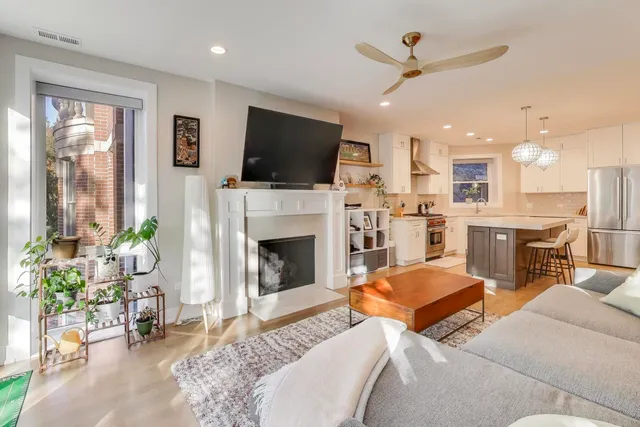 a living room with furniture a flat screen tv and a fireplace