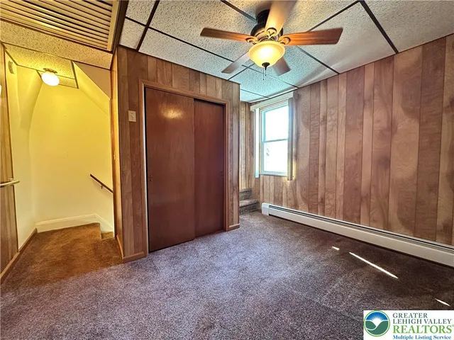 an empty room with windows and a ceiling fan